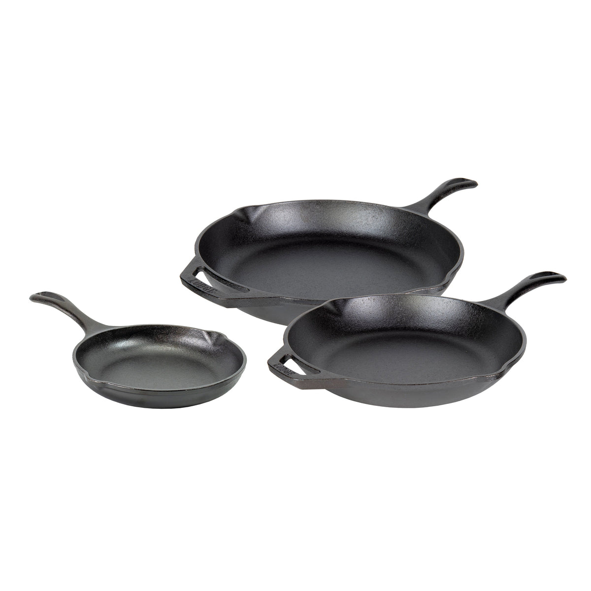 Set of three black cast iron skillets on a white background