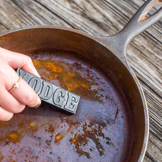 Someone using eraser to remove rust from skillet.