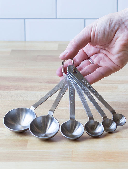 Someone holding measuring spoons.