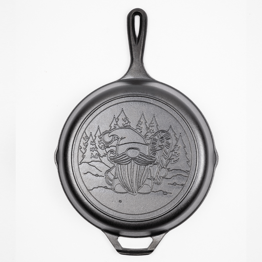 Cast Iron Skillet with a Gnome holding a candy cane in a snowy forest engraved on back.