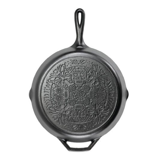 A black cast iron skillet with a butterfly sugar skull design on bottom of skillet.