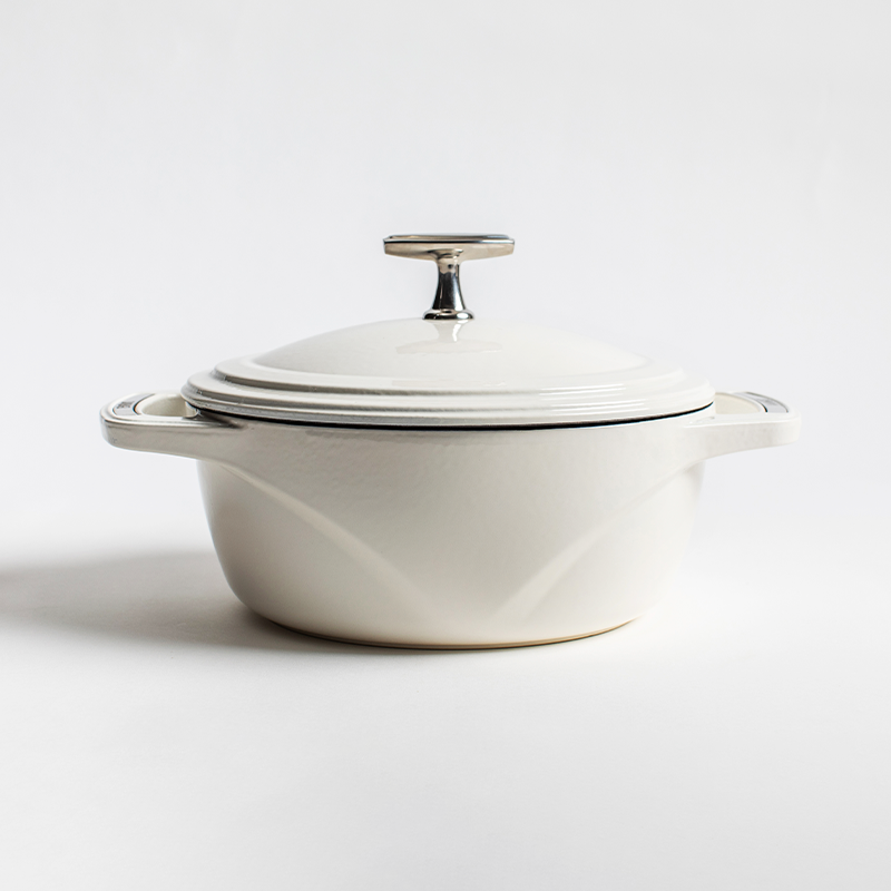 White enameled cast iron Dutch oven with a lid on a white background
