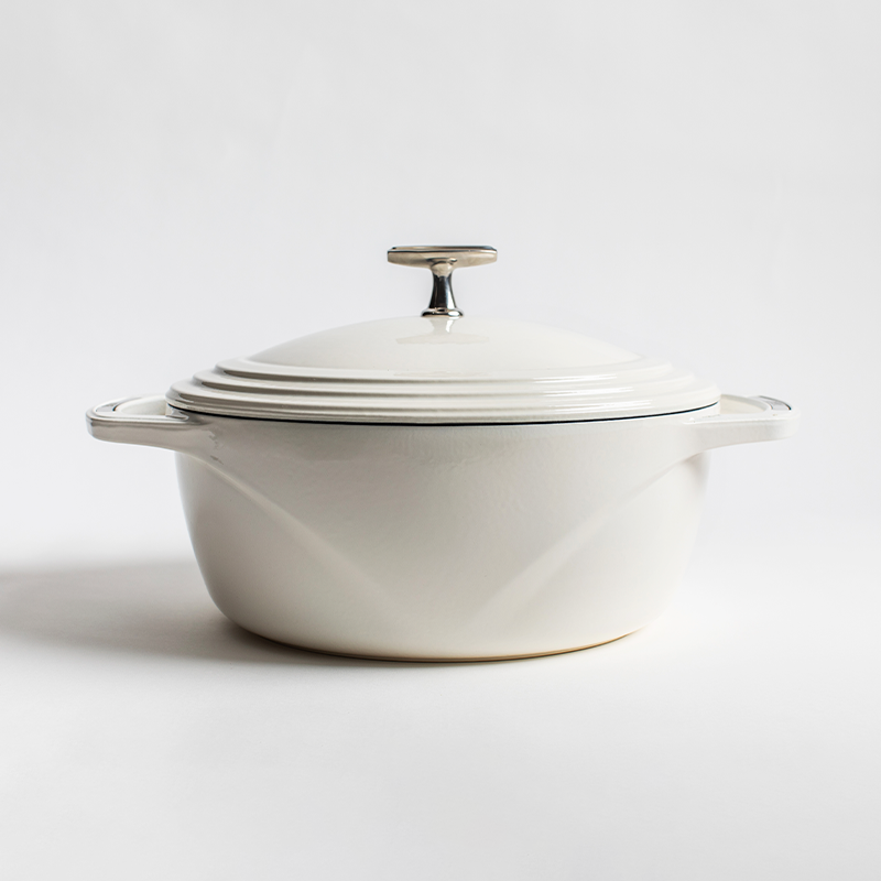 White enameled cast iron Dutch oven with a lid on a white background