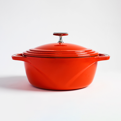 Red enameled cast iron Dutch oven with a lid on a white background