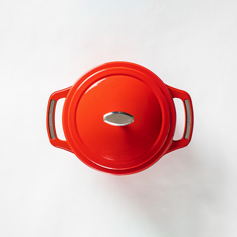 Top of red dutch oven lid with silver lid knob and silver accents on handles.