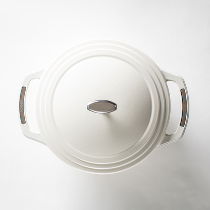 Top of white dutch oven lid with silver lid knob and silver accents on handles.