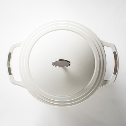Top of white dutch oven lid with silver lid knob and silver accents on handles.