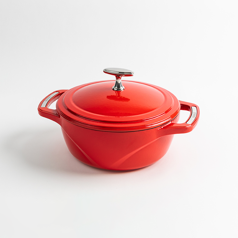 Red enameled cast iron Dutch oven with a lid on a white background