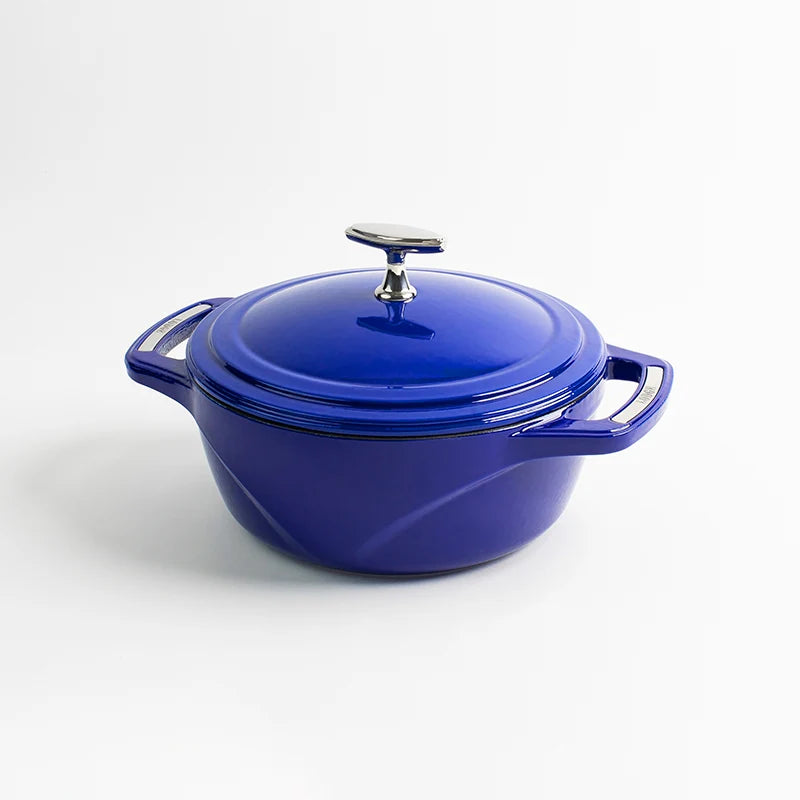 Blue enameled cast iron Dutch oven with a lid on a white background