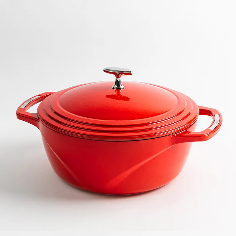 Red enameled cast iron Dutch oven with a lid on a white background