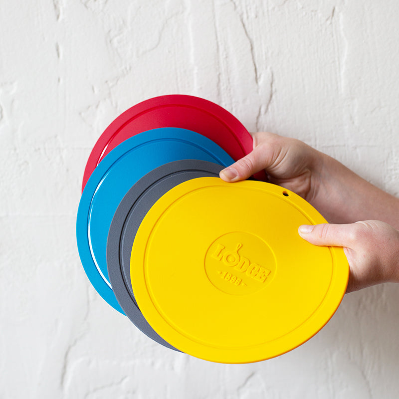 Someone holding all 4 color options; red, blue, grey, and yellow.