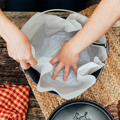 Someone flattening liner bottom to fit dutch oven.