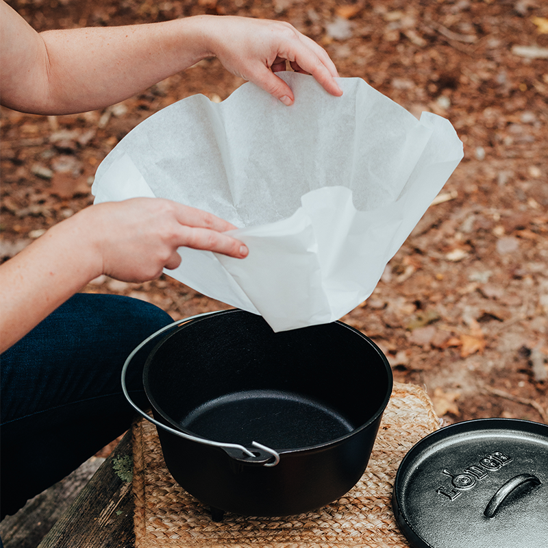 Someone placing liner into camp dutch oven.