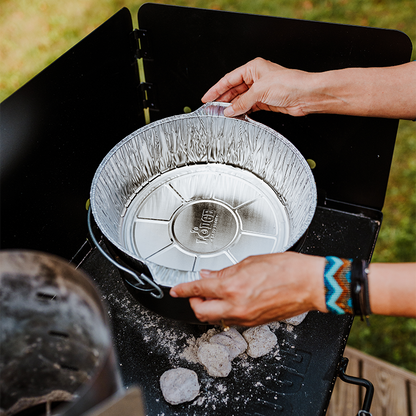 Someone placing liner in camp dutch oven.