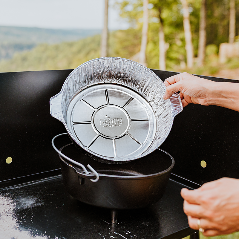 Someone placing liner in camp dutch oven.