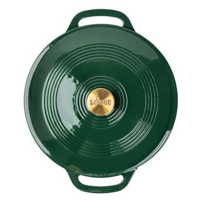 A top-down view of a dark green enameled cast iron braiser with a gold-tone center knob featuring the embossed brand name 'LODGE'.