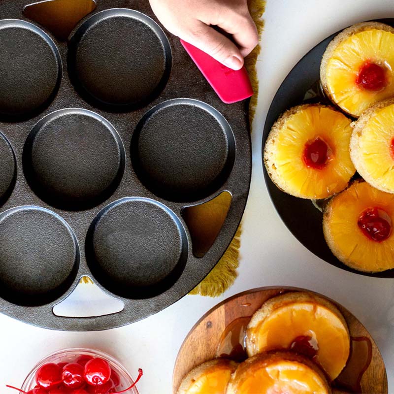 Someone using the Lodge bakeware grips to move pan after baking upside down pineapple cakes.
