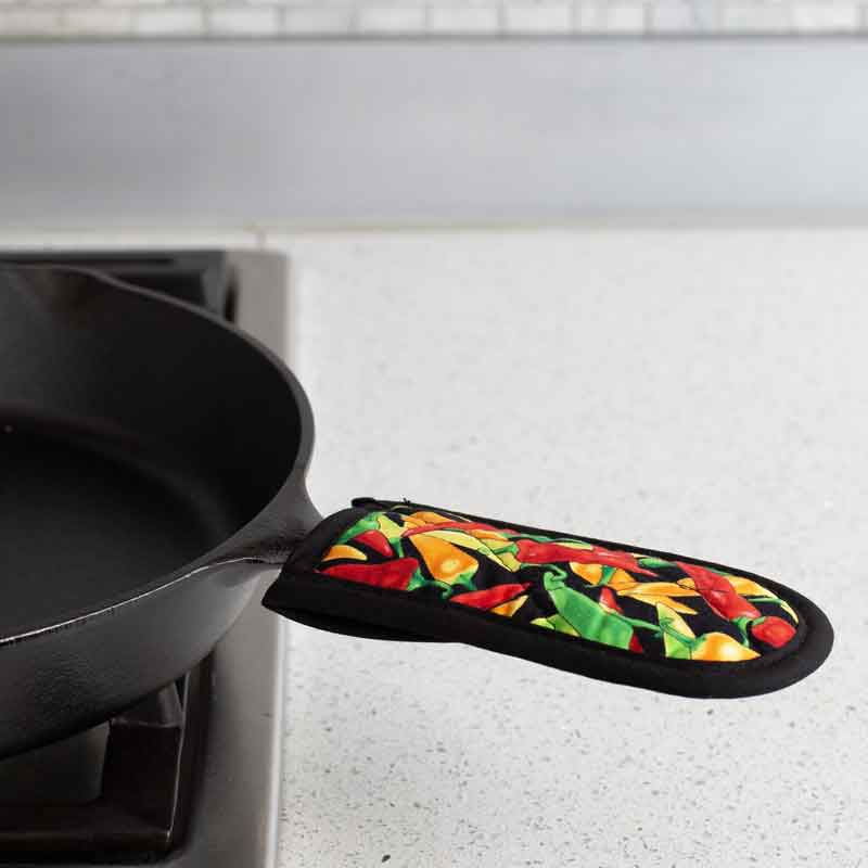 Handle holder being used on skillet on stove.