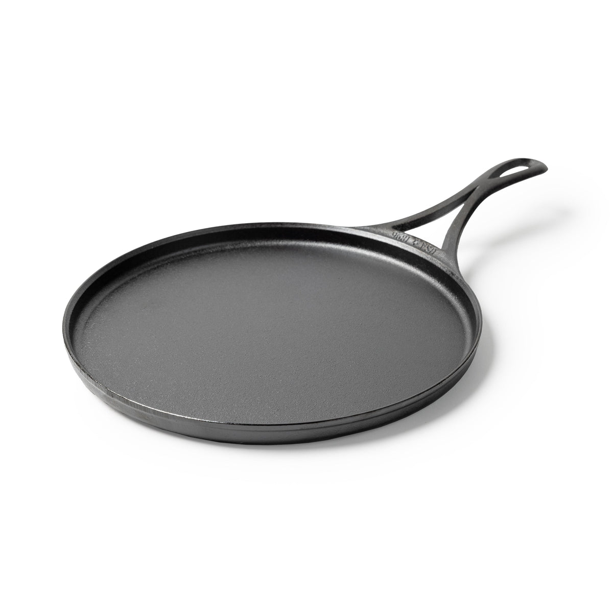Black circular griddle with a long handle and shallow edges.