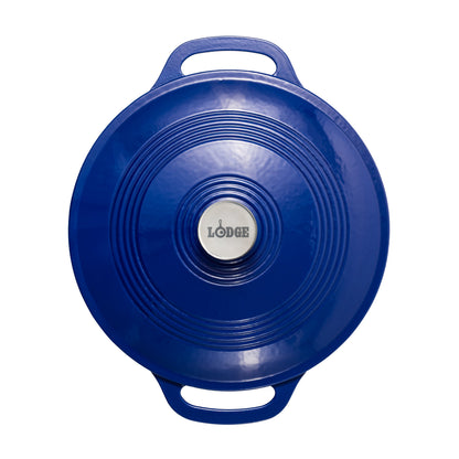 A blue Lodge round braiser with integrated handles and a silver center knob featuring the Lodge logo, shown against a plain white background.