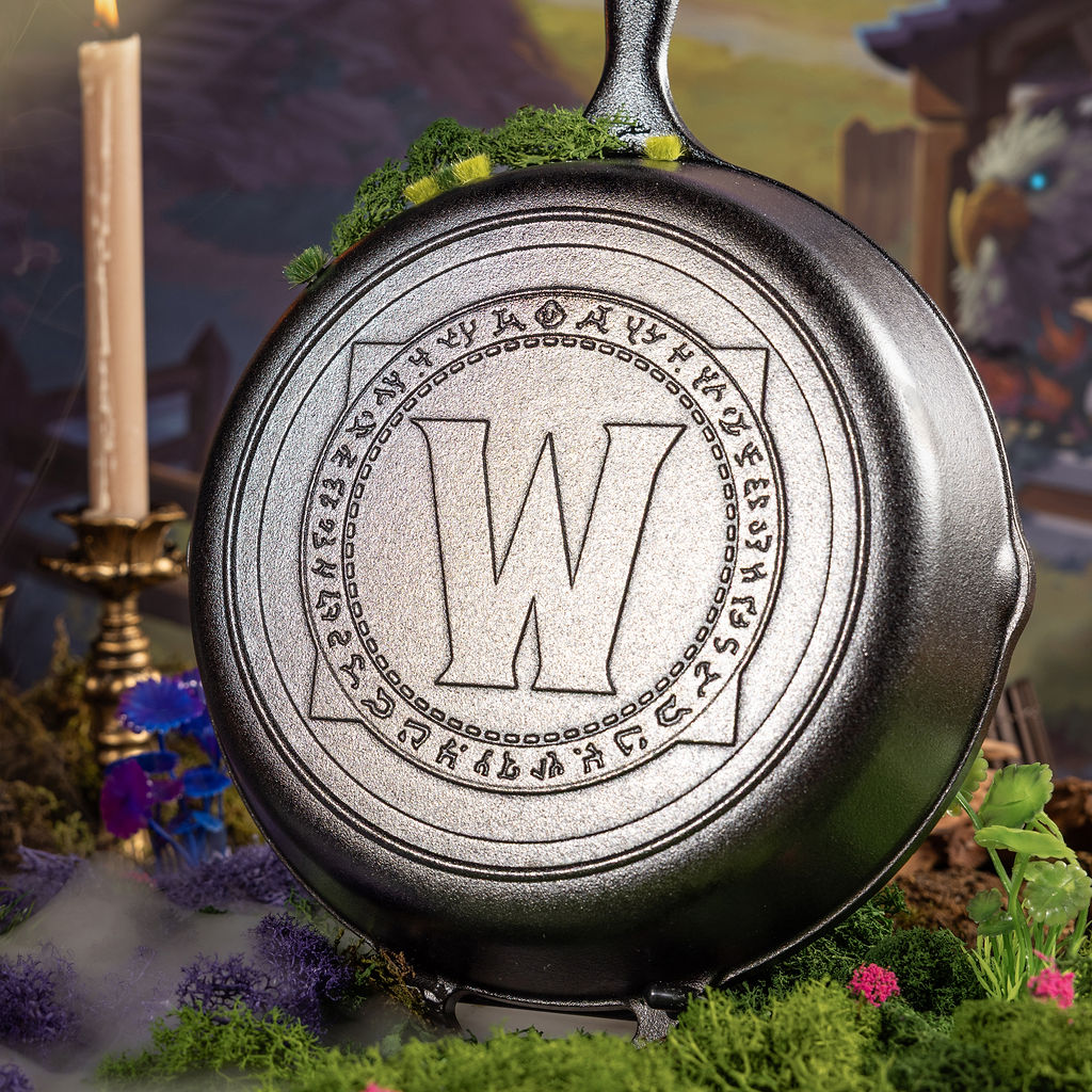 Cast iron skillet in a fantasy setting with flowers and a candle.