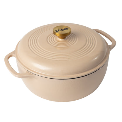 Latte cream enameled cast iron Dutch oven including a lid with gold knob.