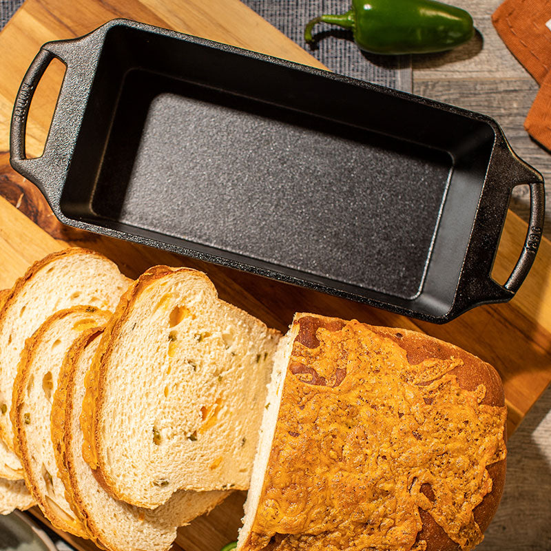 Loaf pan next to sliced bread loaf.