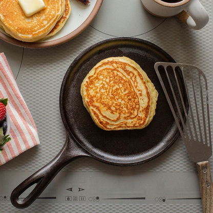 Pancake being cooked on griddle over stove.