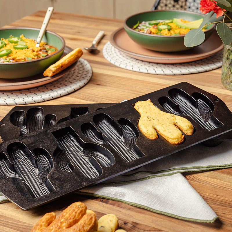 Display of 2 pans, with one mold filled with baked cornbread shaped like a cactus.