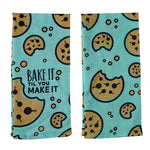 Folded turquoise towel, visual of the front and back, with chocolate chip cookie graphics throughout and the text "Bake it Til You Make It" on the front.