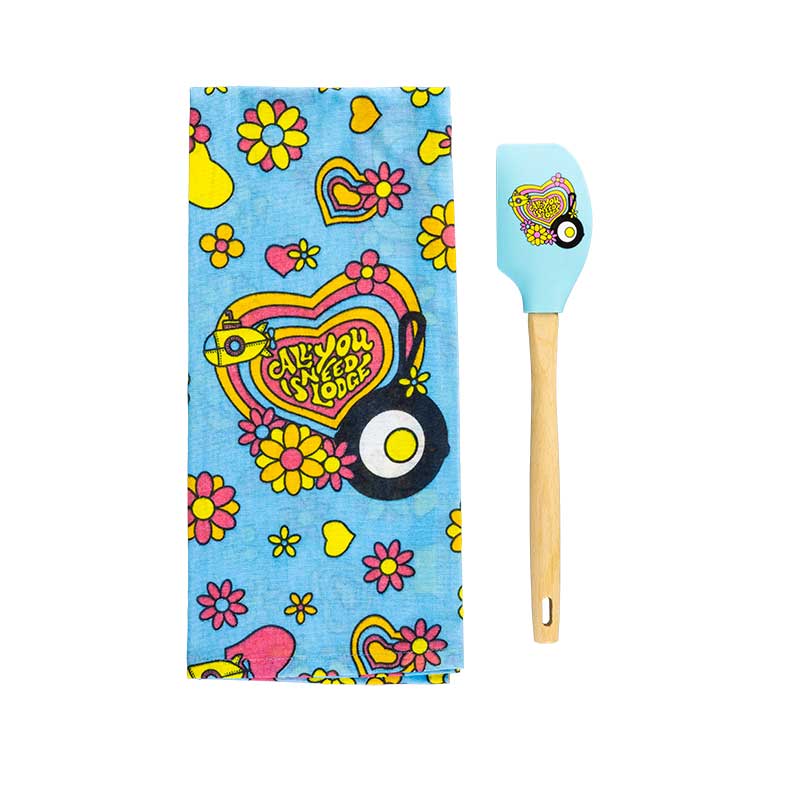 Colorful kitchen towel with heart and flower design and matching spatula on a white background