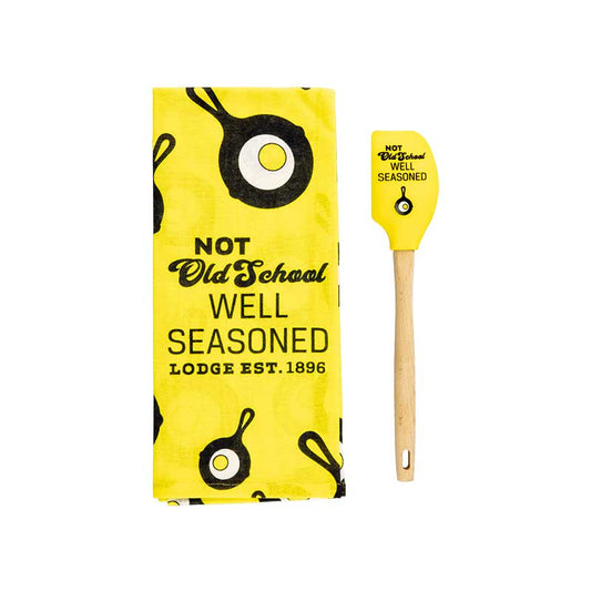 Set including yellow kitchen towel and yellow spatula, both with the Lodge skillet and egg logo and the text "Not older school well seasoned".