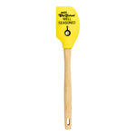 Yellow spatula with wooden handle and black text saying "Not Old School Well seasoned" above the Lodge skillet and egg logo.