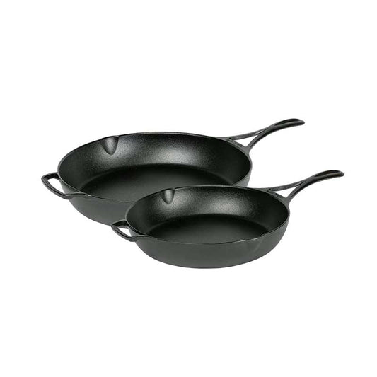 Two black cast iron skillets on a white background