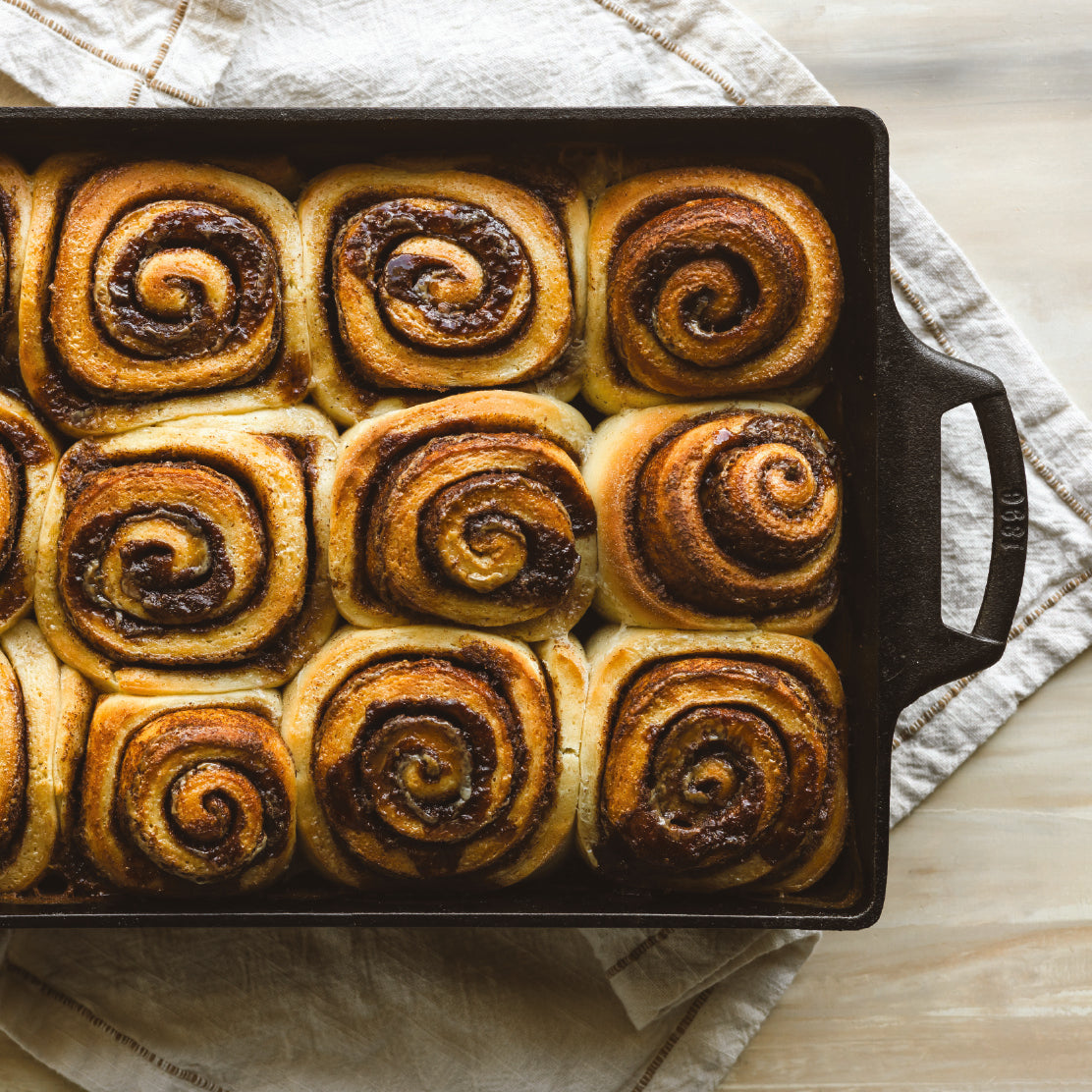 Baked cinnamon rolls in cast iron casserole dish.