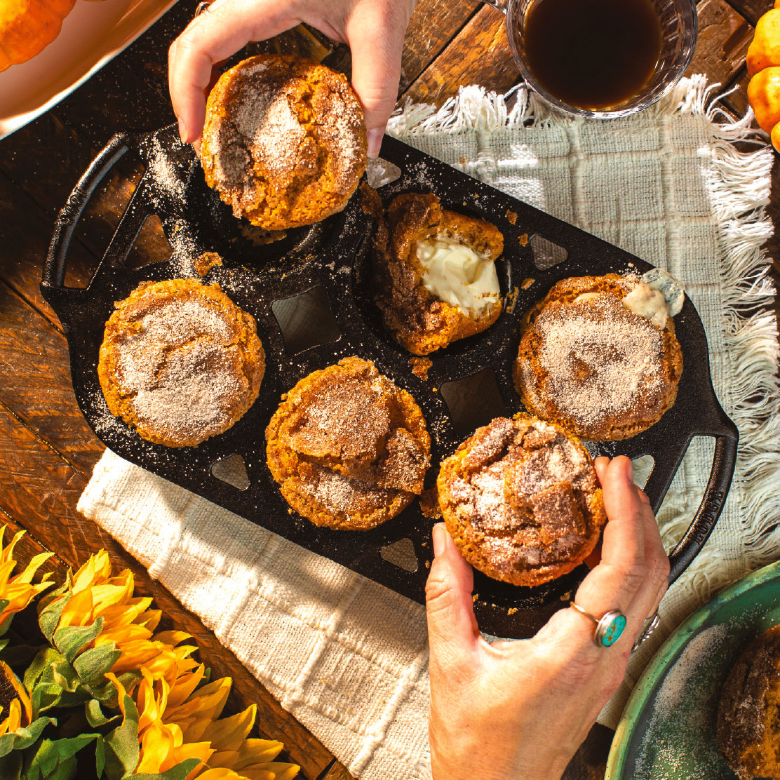 Pumpkin muffins being eaten from a cast iron muffin pan.