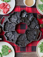 Decorative pan for Christmas shaped cake designs on a red and black checkered tablecloth.