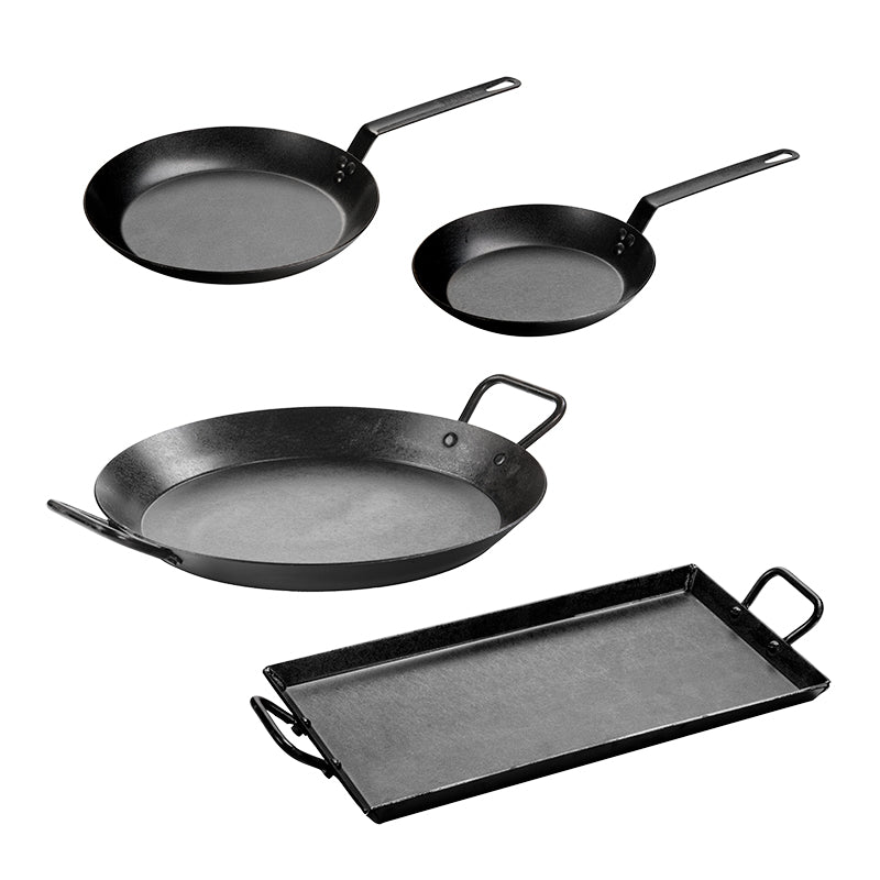 Set of four black carbon steel cookware items on a white background
