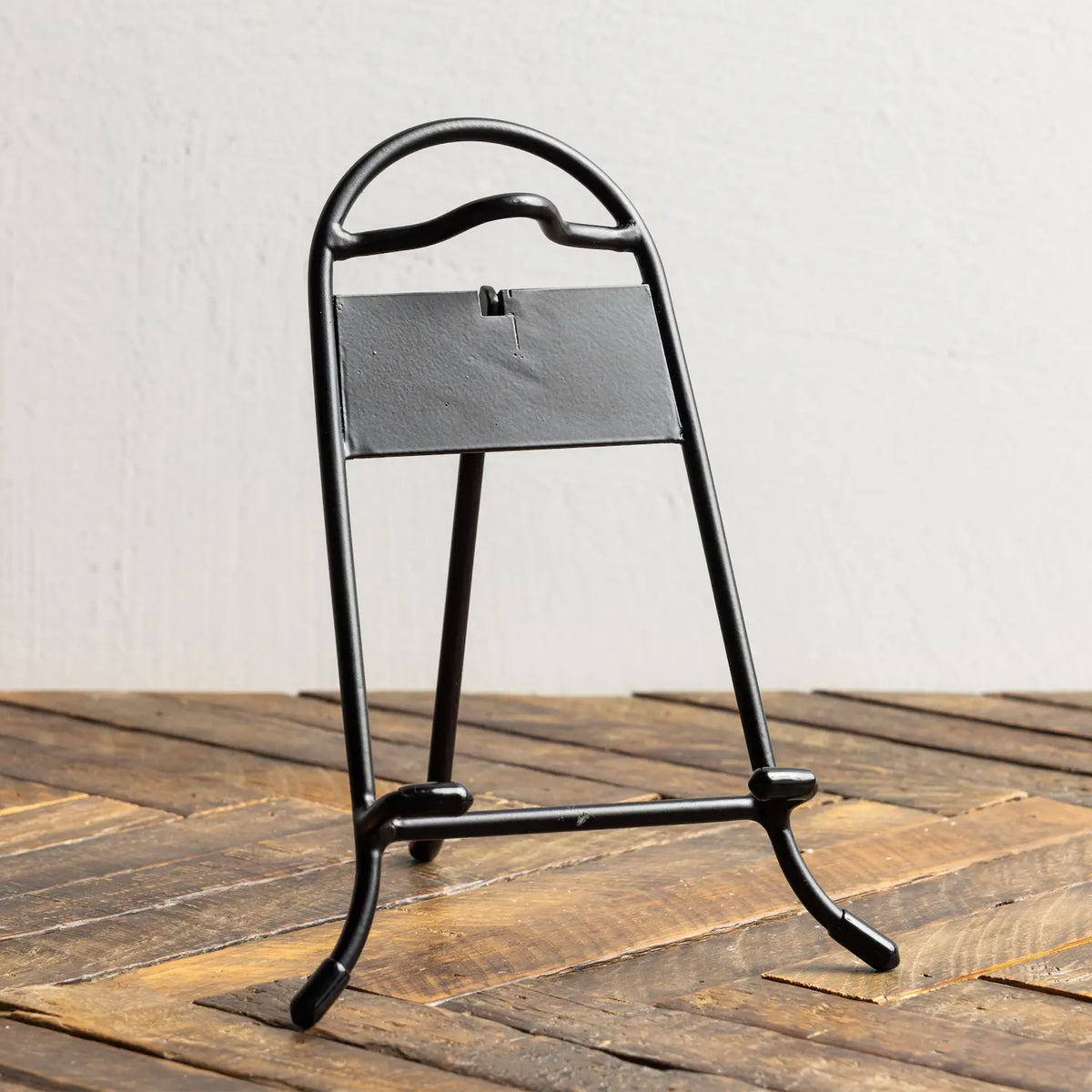 Black metal stand with a gray mat on a wooden surface