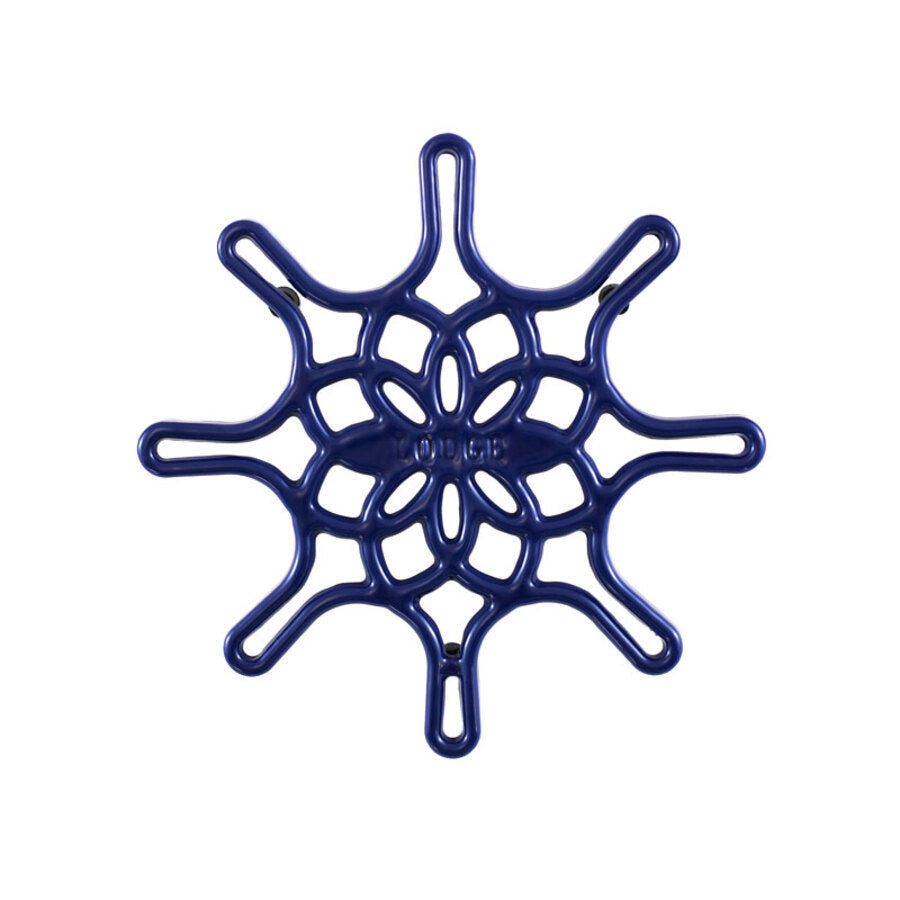 An indigo enameled cast iron trivet with a geometric snowflake-like pattern.