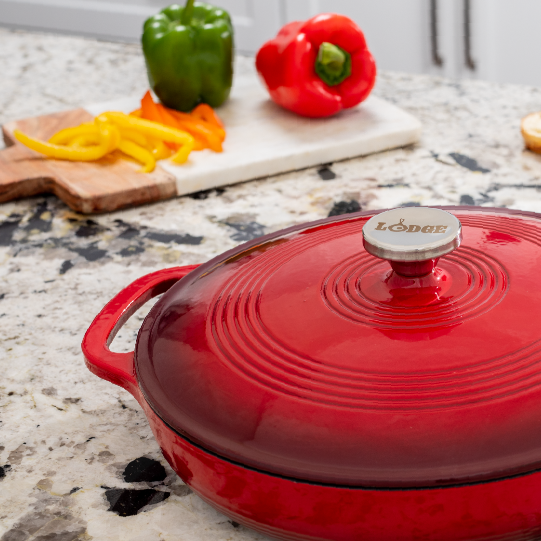 Braiser on kitchen counter in front of chopped peppers.