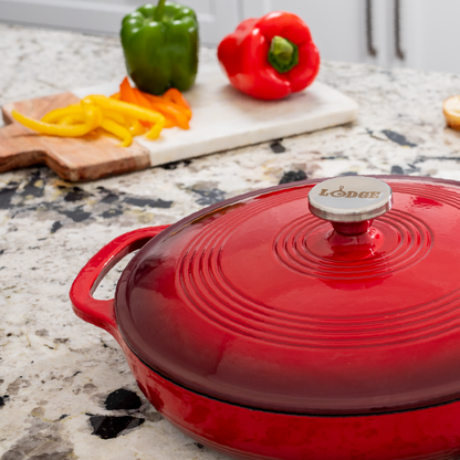 Braiser on kitchen counter in front of chopped peppers.