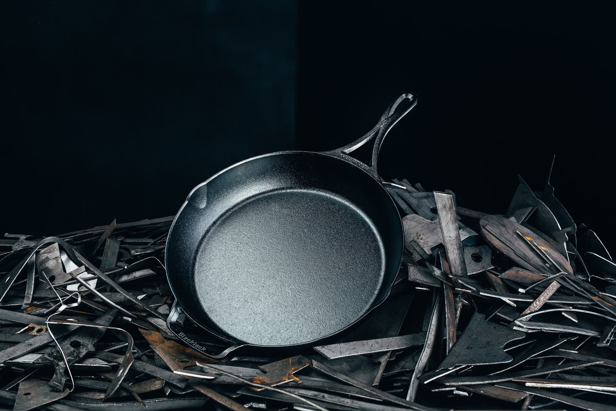 Skillet laying in pile of pieces of iron.