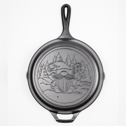 Cast Iron Skillet with a Gnome holding a candy cane in a snowy forest engraved on back.