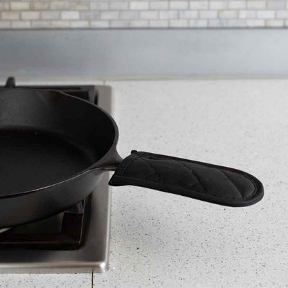 Handle holder being used on pan cooking on stove.