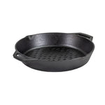 Black cast iron skillet with holes on bottom, along with 2 handles and pour spouts.