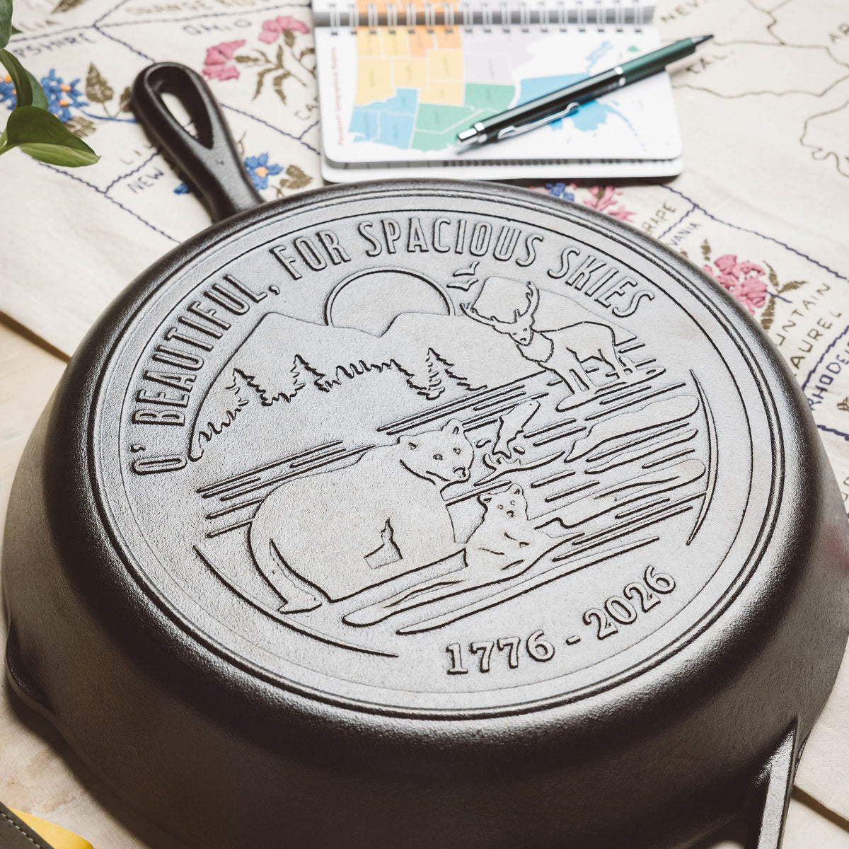 Close-up view of skillet design on a floral and map background.