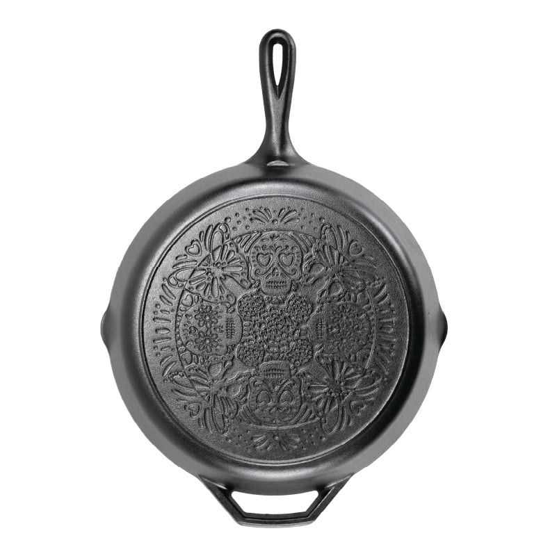 A black cast iron skillet with a butterfly sugar skull design on bottom of skillet.
