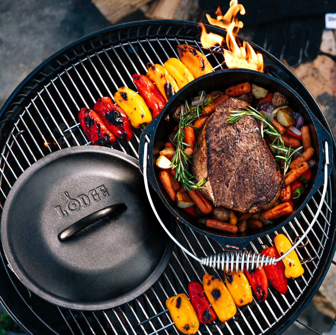 Beef chuck roast being prepared in dutch oven on grill.
