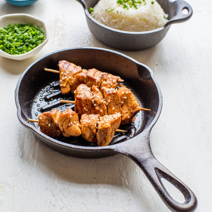 Sesame chicken skewers freshly made and served on pan.